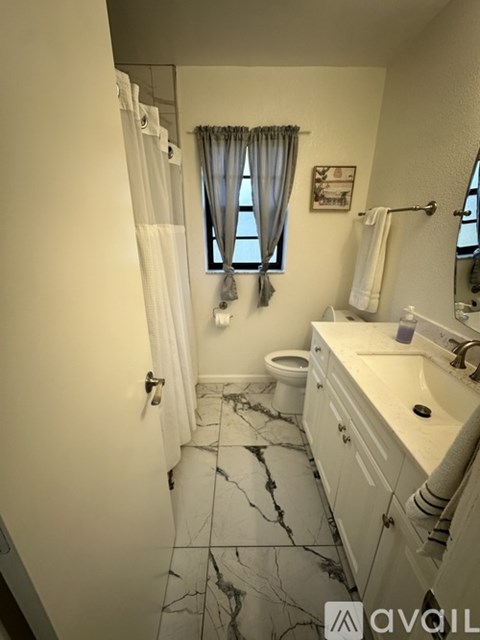 A bathroom with a marble floor and white walls.