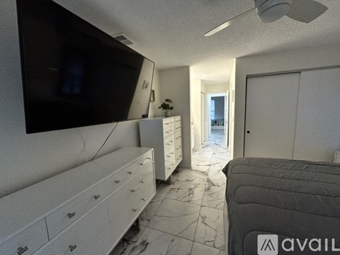 A living room with a television, drawers, and a couch.