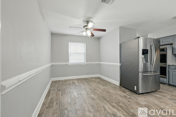 A kitchen with a stainless steel refrigerator and a ceiling fan.