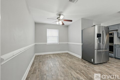 A kitchen with a stainless steel refrigerator and a ceiling fan.