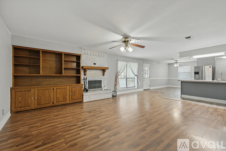 A spacious living room with wooden floors and a fireplace.