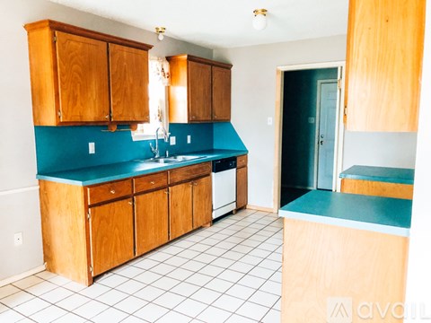 A kitchen with wooden cabinets and a blue counter.