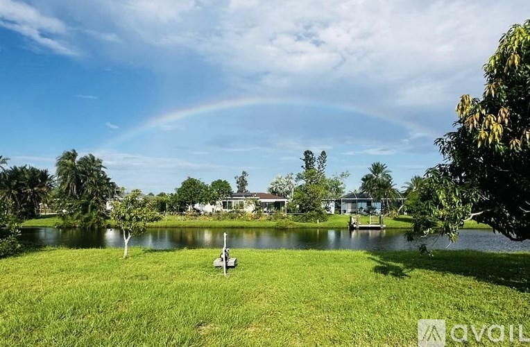A serene landscape with a rainbow arching over a lake.