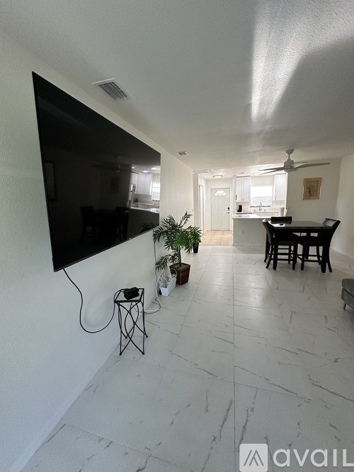 A living room with a flat screen TV mounted on the wall.
