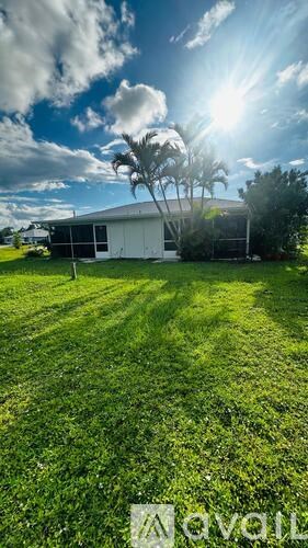 A white building with a palm tree in front of it.