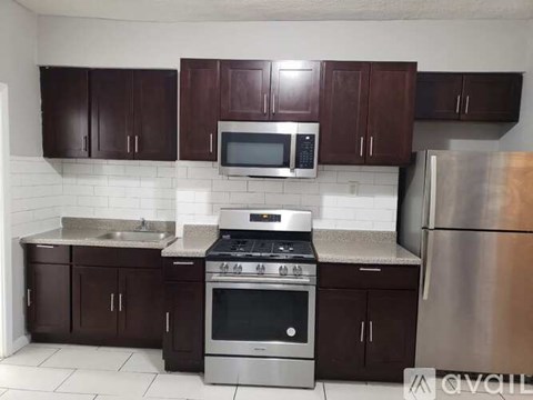 A kitchen with brown cabinets and stainless steel appliances.