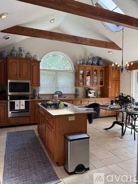 A kitchen with wooden cabinets and a large island.