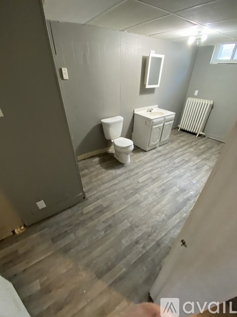 A bathroom with a toilet, sink, and radiator.