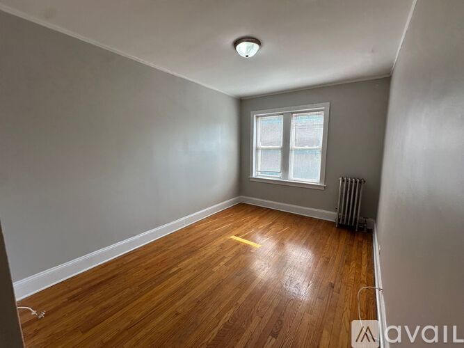A room with wooden flooring and a window.