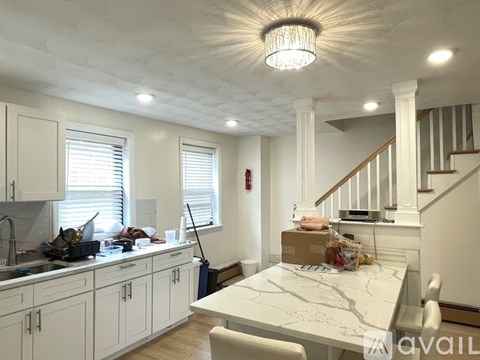 A kitchen with white cabinets and a marble countertop.