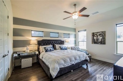A bedroom with a large bed and a ceiling fan.