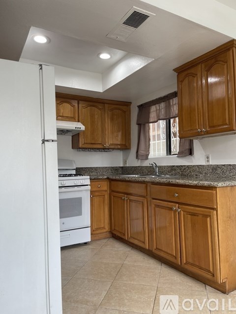 A kitchen with wooden cabinets and a white refrigerator.