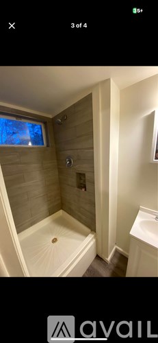 A bathroom with a wooden wall and a window.