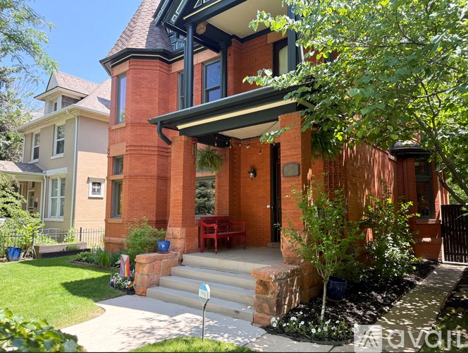 A house with a front porch and a car parked in front.