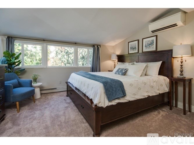 A bedroom with a large bed and a blue chair.