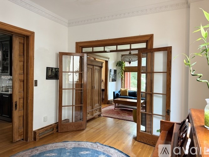 A bedroom with a large bed, a dresser, and a chair.