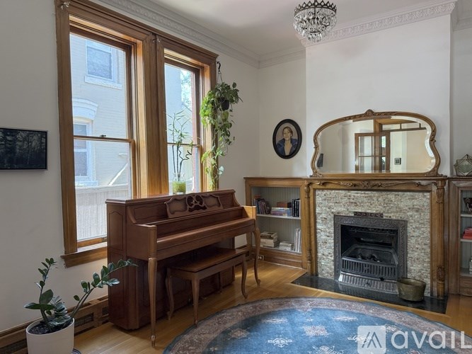 A white bathtub sits in a bathroom with a large mirror and wooden cabinets.