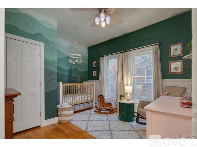 A baby's room with a crib, rocking chair, and pictures on the wall.