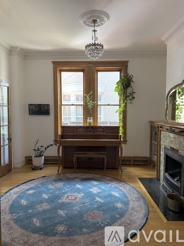 A room with a white cabinet and a round mirror on the wall.