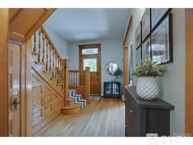 A wooden staircase with a white railing leads to the second floor of a house.