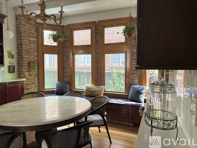 A cozy attic room with a window seat and a small table.