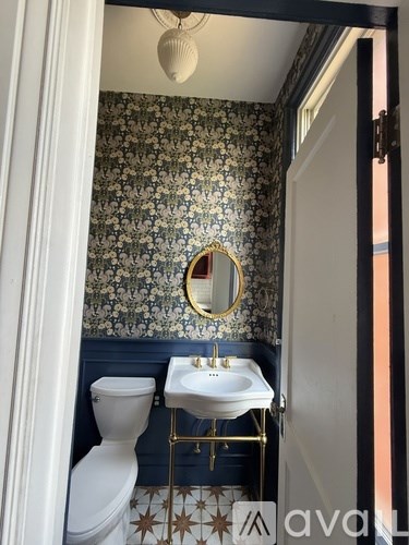 A backyard with a tree, a bench, and a grill.