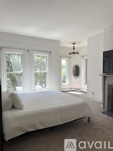 A bedroom with a large bed and a fireplace.