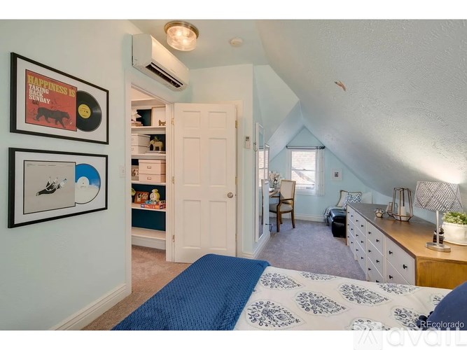 A bedroom with a bed, desk, and chair.