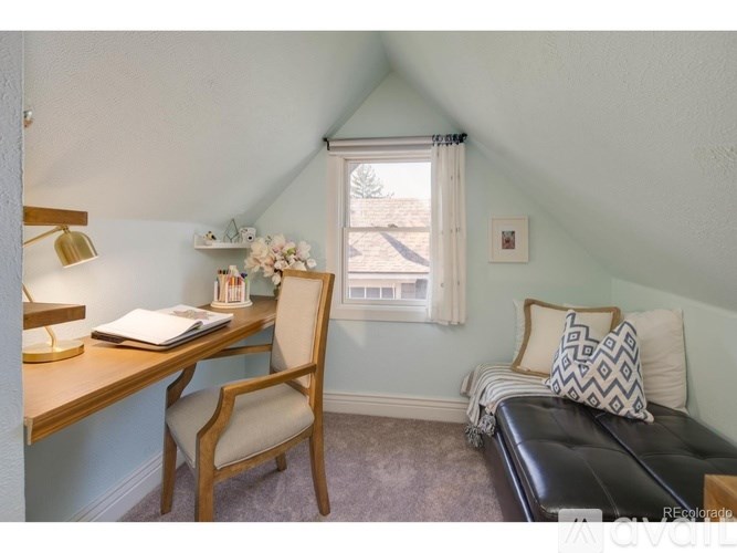 A room with a desk, chair, and bed.