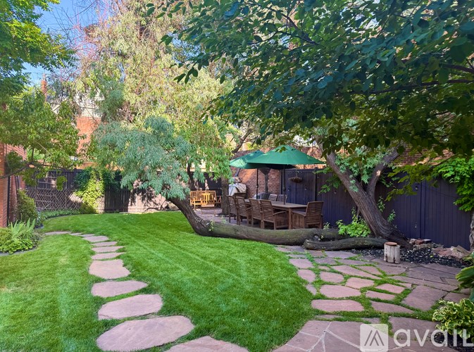 A backyard with a stone pathway and a wooden deck.