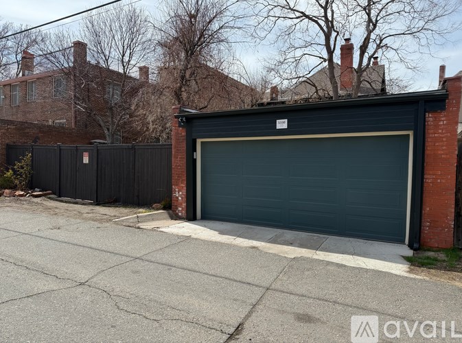 A black garage door is closed and there is a white sticker on it.