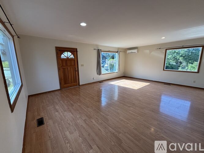 A room with wooden flooring and a door is available for rent.