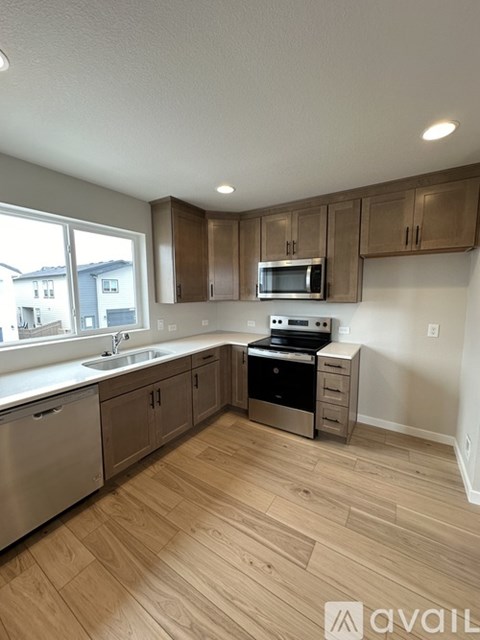 A kitchen with wooden cabinets and a stainless steel dishwasher.