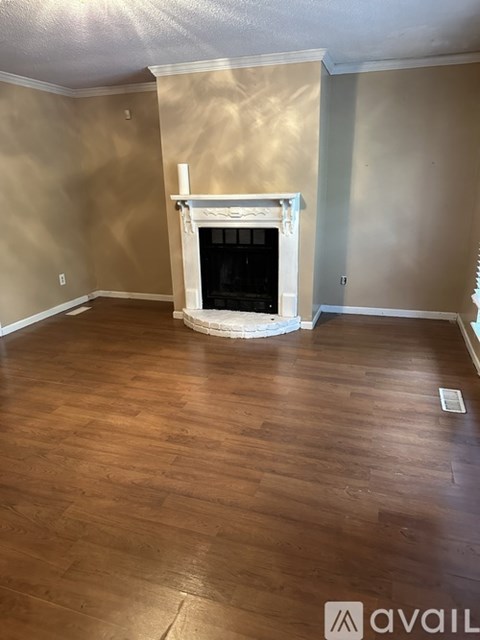 A living room with a fireplace and wood flooring.