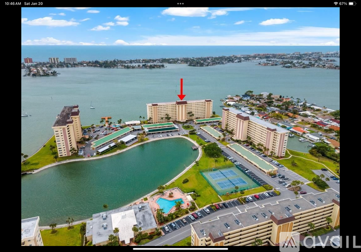 A red arrow points to a building in a large complex with a pool.