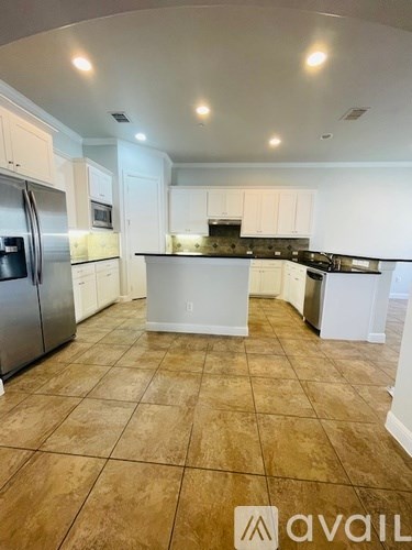 A kitchen with white cabinets and a tile floor.