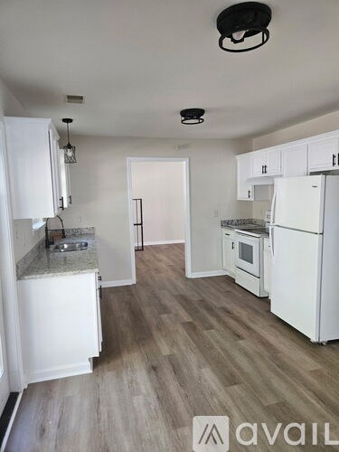 A kitchen with white appliances and cabinets.