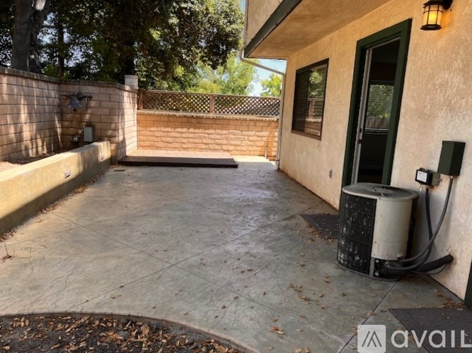 A patio area with a concrete floor and a wall with a green door.