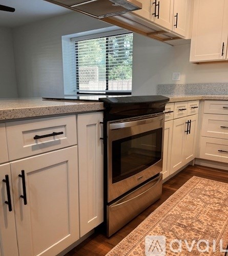 A kitchen with white cabinets and a brown oven.