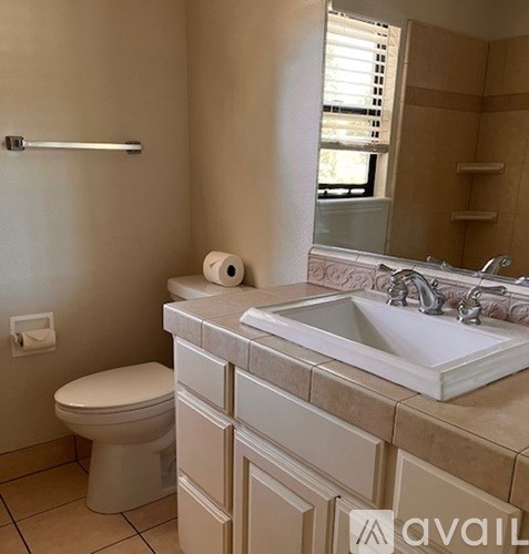 A bathroom with a toilet, sink, and mirror.