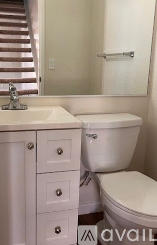 A white toilet sits next to a sink in a bathroom.