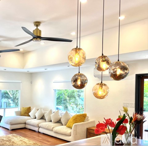 A living room with a white couch and a ceiling fan.