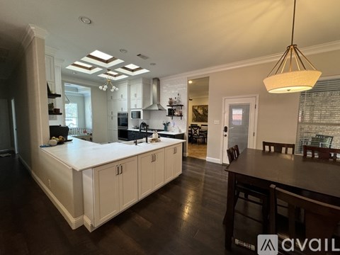 A kitchen with white cabinets and a wooden table.