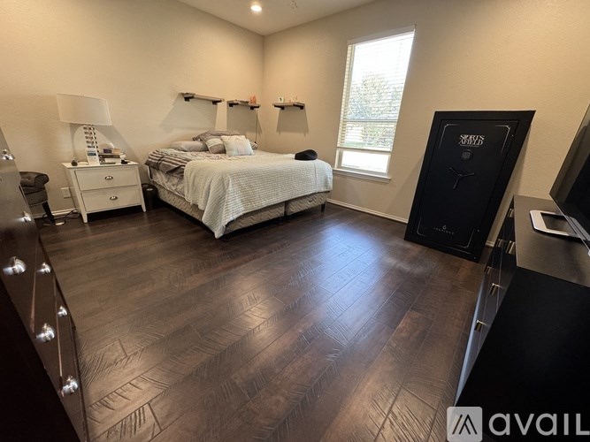 A bedroom with a large bed and a wooden floor.
