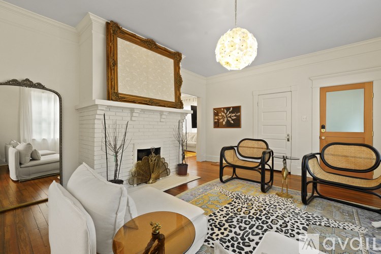 A living room with a fireplace and two chairs.