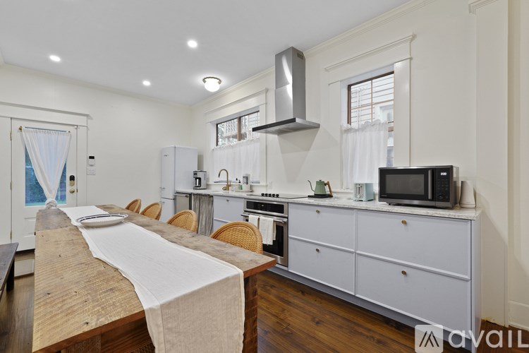 A kitchen with a wooden table and white cabinets.