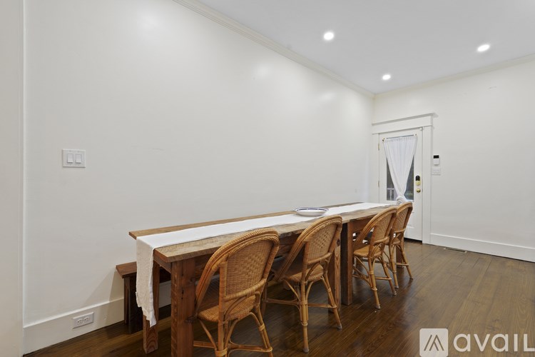 A long wooden table surrounded by chairs in a room.