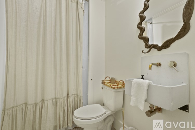 A white toilet sits next to a white sink in a bathroom.