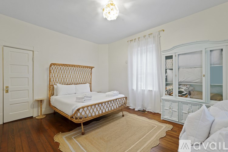 A bedroom with a bed, dresser, and window.