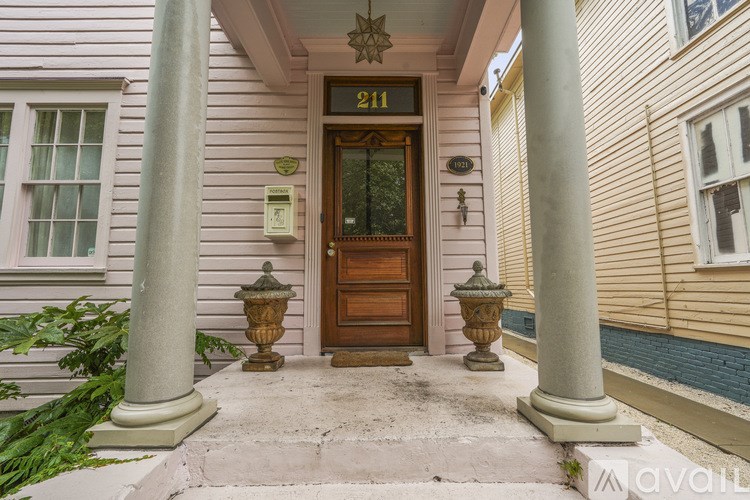 A house numbered 211 with a wooden door and two columns.
